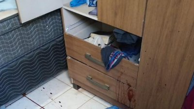 Corpo da vítima fatal foi encontrado no chão, ao lado da cama: móvel onde roupas eram guardadas ficou com manchas de sangue nas gavetas [Foto: Divulgação/PM]